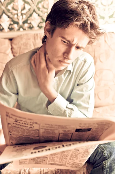 Closeup portrait of young man with newspaper — Stock Photo, Image