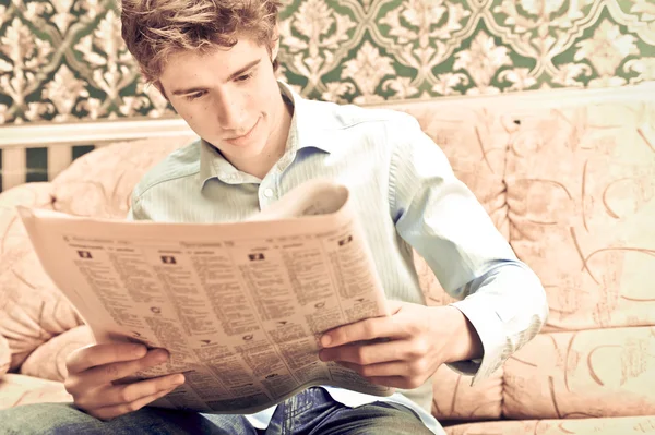 Closeup portrait of young man with newspaper — Stock Photo, Image