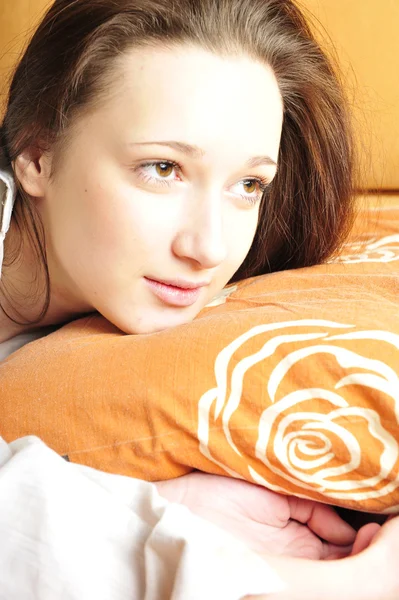Closeup portrait of young pretty girl laying on her bed — Stock Photo, Image
