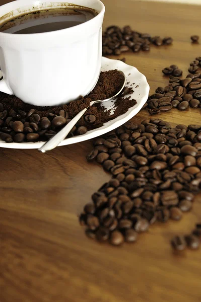 Dramatic photo of world map made of coffee beans. White cup with — Stock Photo, Image
