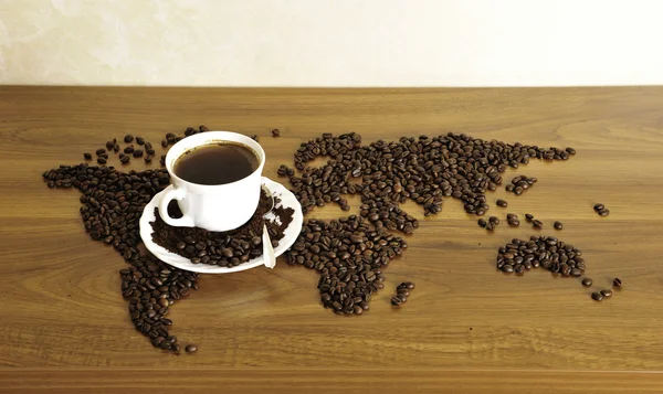 Драматическое фото карты мира из кофейных зерен. Белая чашка с — стоковое фото