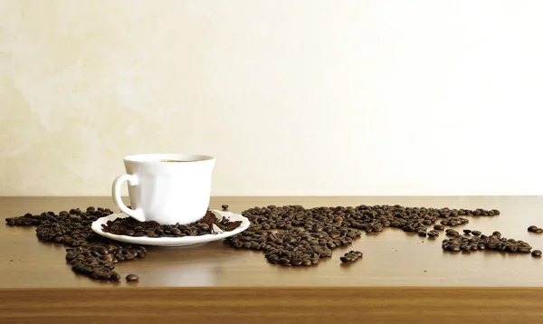 Dramatic photo of world map made of coffee beans. White cup with — Stock Photo, Image