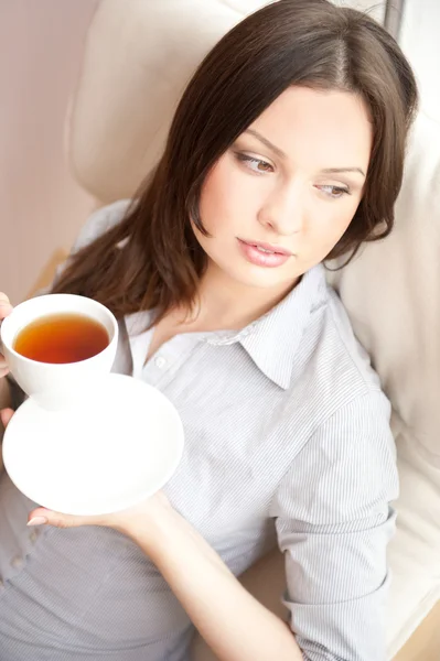 Young woman at home sipping tea from a cup — Stock Photo, Image