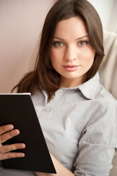 Portrait of a happy young brunette woman holding book — Stock Photo, Image