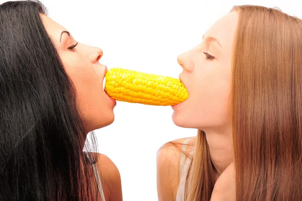 Two women eating corn at the same time from different sides — Stock Photo, Image