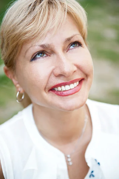 Portréja egy nő mosolyog egy parkban — Stock Fotó