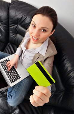 Portrait of beautiful business woman with laptop and credit card clipart