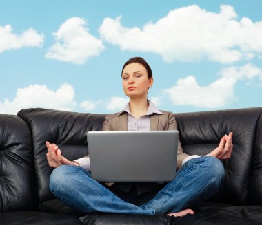 Portrait of young business woman sitting with a laptop on comfor clipart