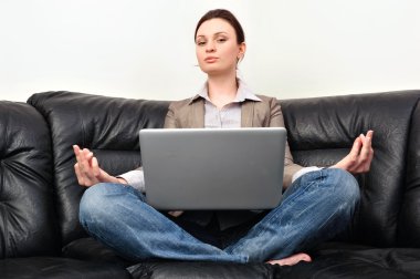 Portrait of young business woman sitting with a laptop on comfor clipart