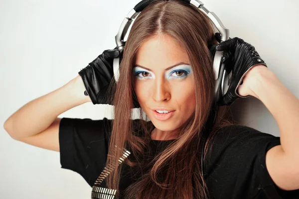 Club style woman with headphones listening to music looking at c — Stock Photo, Image