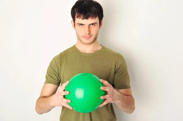 Retrato de homem bonito segurando bola verde em seus braços. Standin. — Fotografia de Stock