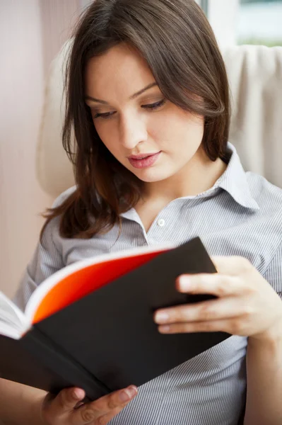 Giovane donna sexy a casa lettura libro — Foto Stock