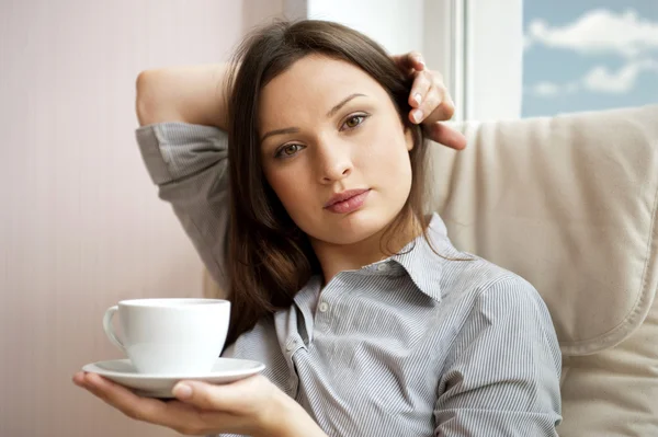 Mujer joven en casa bebiendo té de una taza —  Fotos de Stock