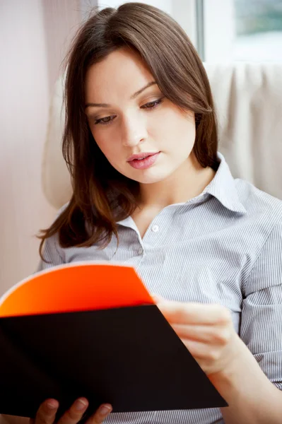 Молодая сексуальная женщина дома читает книгу — стоковое фото