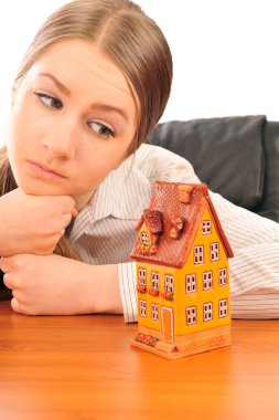 Young beautiful business woman with house model - real estate. S clipart