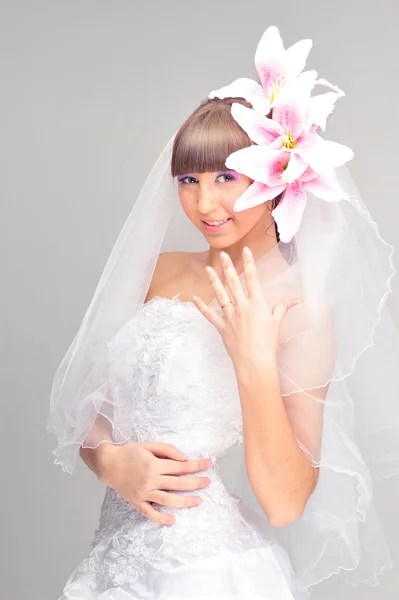 Gelukkig jonge bruid in bruiloft jurk met bloem decoratie in hai — Stockfoto