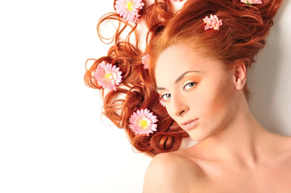 Hermosa mujer con flores en su pelo rojo ella está tumbada relajar — Foto de Stock