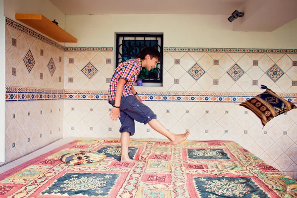 stock image Artistic lifestyle photo of young boy kicking pillow standing on