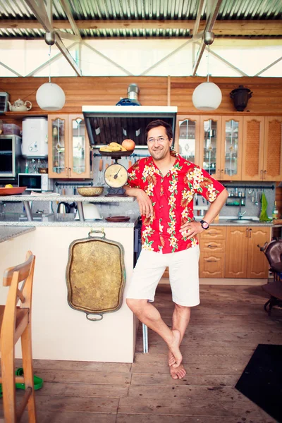 Художній спосіб життя фото дорослого дружнього чоловіка на своїй кухні в — стокове фото