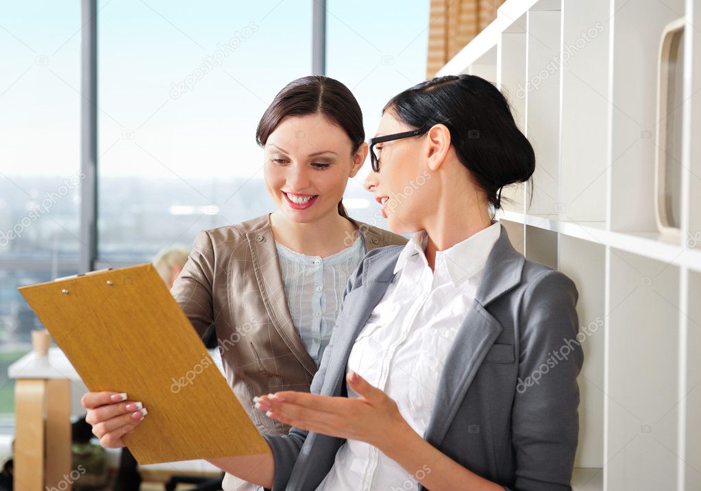 Two business women reading documents