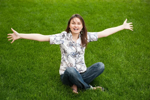 stock image Full length of pretty young woman resting on grass and smiling