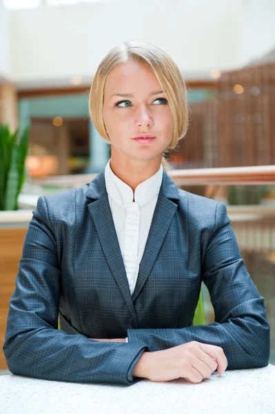 Portrait of pretty young businesswoman sitting relaxed and looki — Stock Photo, Image