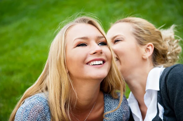 Zwei Frauen flüstern und lächeln — Stockfoto