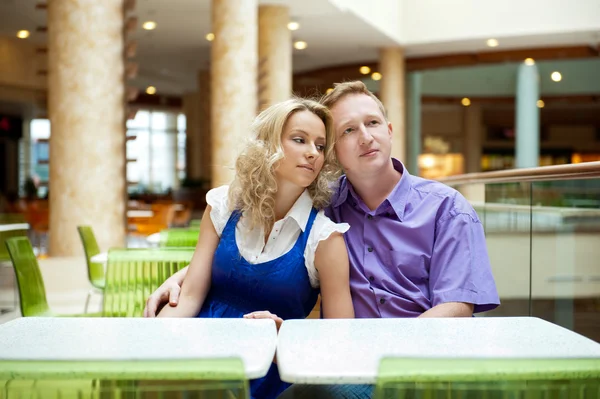 Retrato de um jovem casal feliz olhando para longe enquanto sentado perto — Fotografia de Stock