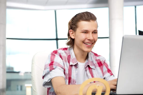 Portret van knappe jonge man met laptop bezig met freelance — Stockfoto