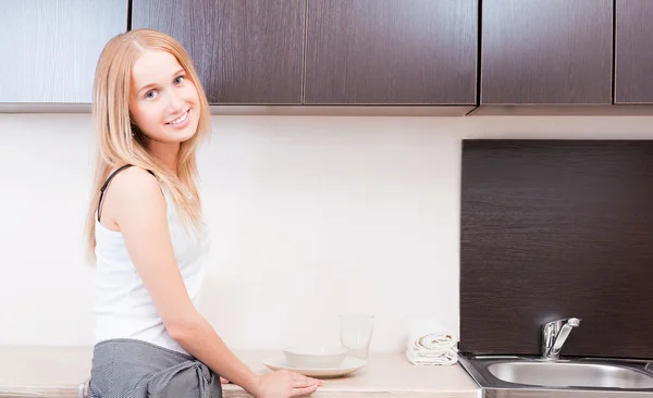Porträt einer schönen entspannten jungen Frau, die an der Küche steht — Stockfoto