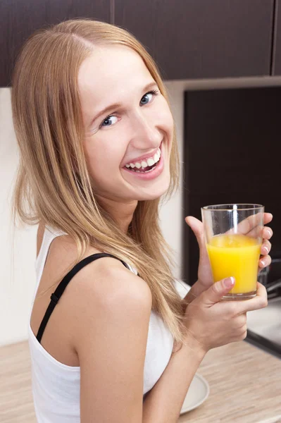 Портрет красивой расслабленной молодой женщины, стоящей на кухне — стоковое фото