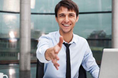 Happy mature business man offering a welcoming hand clipart