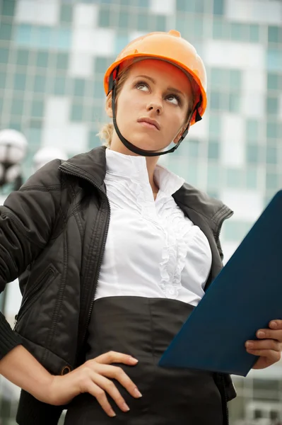 Joven arquitecta-mujer con un casco protector de pie en th —  Fotos de Stock