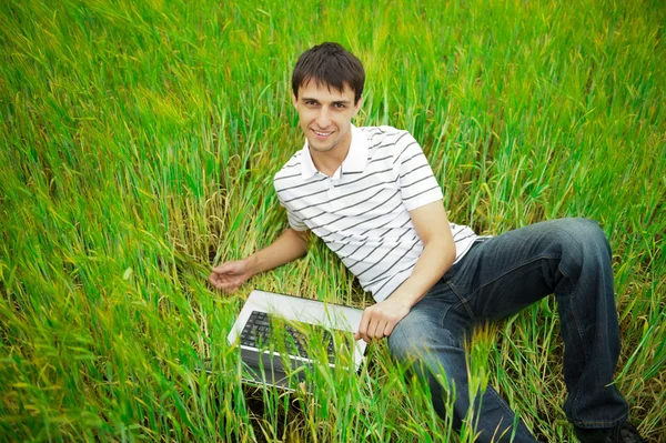 Un hombre sonriente con portátil al aire libre —  Fotos de Stock