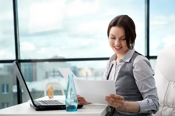 Beautiful business woman looking at papers she holding in her ar — Stock Photo, Image