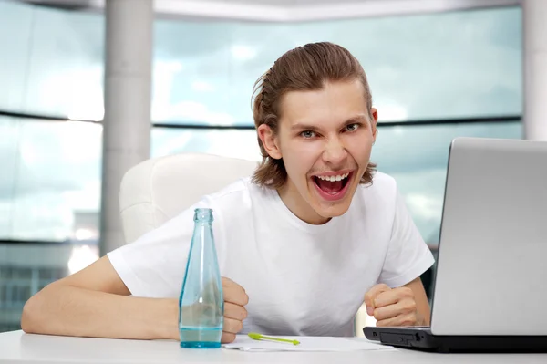 Porträt eines gutaussehenden jungen Mannes, der freiberuflich mit Laptop arbeitet — Stockfoto
