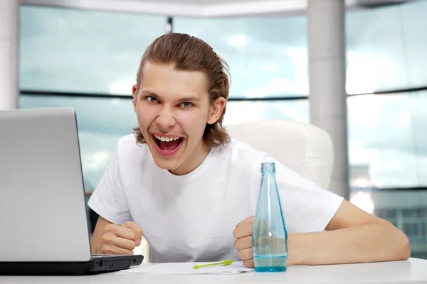 Portret van knappe jonge man met laptop bezig met freelance — Stockfoto