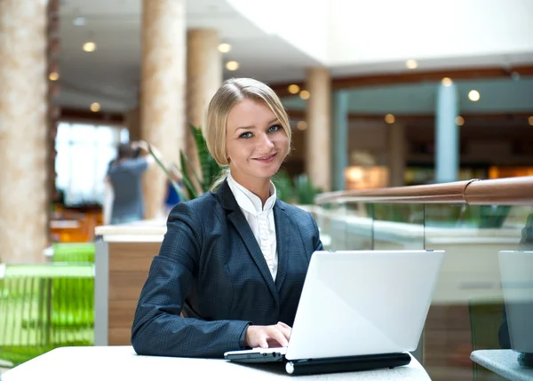 Portret van een mooie zakenvrouw zitten in café met een laptop — Stockfoto