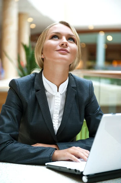 Portret van een mooie zakenvrouw zitten in café met een laptop — Stockfoto