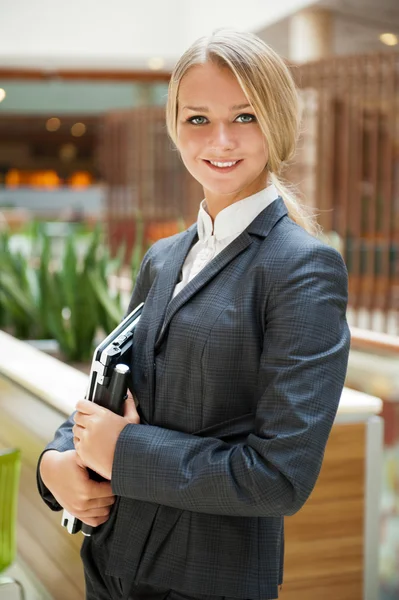 Portret van een schattige zakenvrouw met haar laptop binnen kantoor — Stockfoto