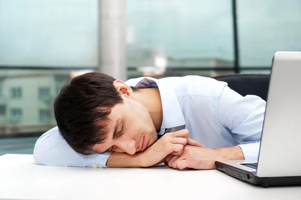 Porträtt av en trött ung affärsman som sover på bordet — 图库照片
