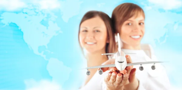 Porträtt av två unga glada kvinnor flygvärdinna håller jet aircraf — Stockfoto