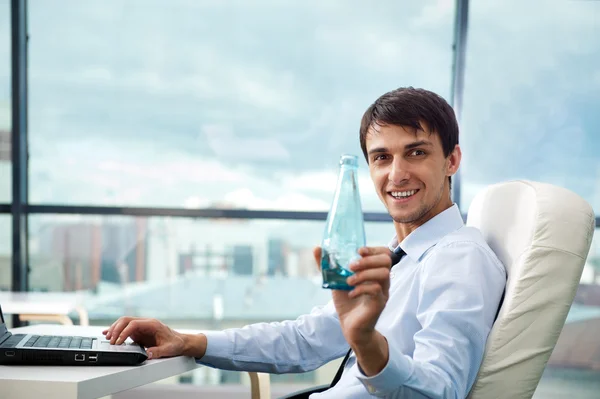 Jovem homem de negócios beber água sentado relaxado na poltrona em — Fotografia de Stock