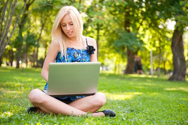 Gyönyörű diák nő ül a zöld fű: laptop — Stock Fotó