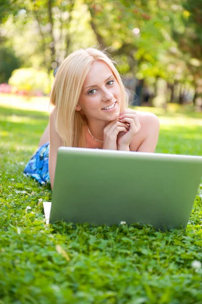Portrait of young pretty woman resting on green grass at summe — Stock Photo, Image