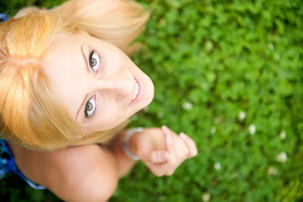 Sonriente hermosa mujer tendida en la hierba. Sonriendo. Foto de abo —  Fotos de Stock