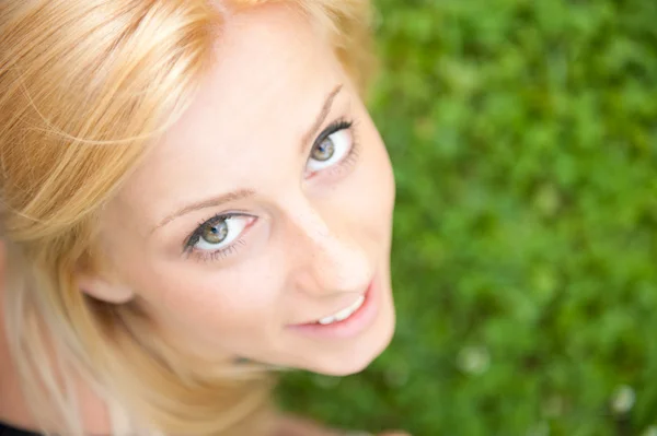 Sonriente hermosa mujer tendida en la hierba. Sonriendo. Foto de abo —  Fotos de Stock
