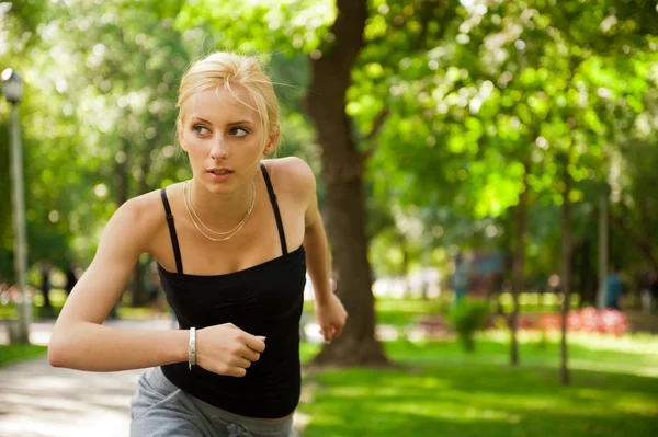 Retrato de jovem mulher bonita em sportswear correndo no parque . — Fotografia de Stock