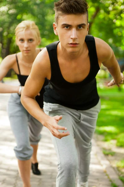 Närbild porträtt av ungt par jogging i park — Stockfoto