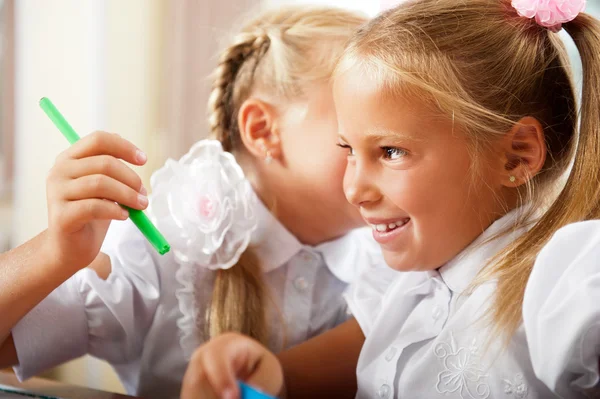 Två små flickor gossip i klassrummet — Stockfoto